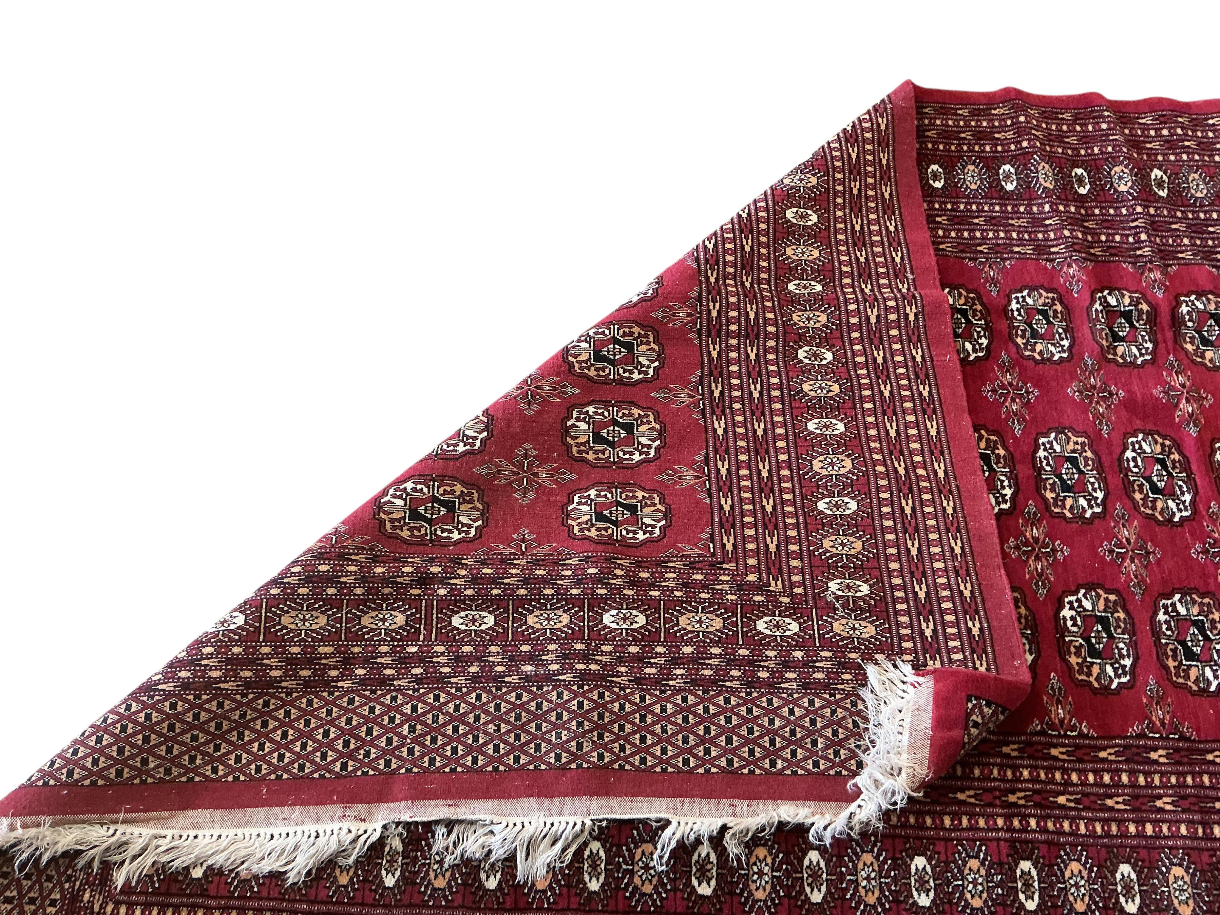 A Bokhara red ground rug, 180 x 130cm